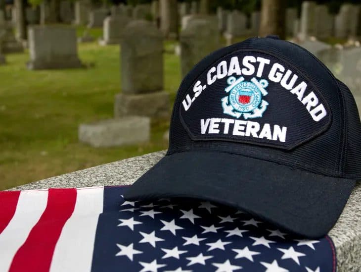 A U.S. Coast Guard veteran cap resting on an American flag