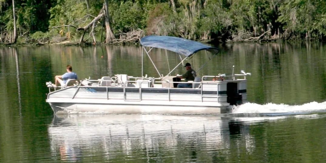 A pontoon boat cruising calm water